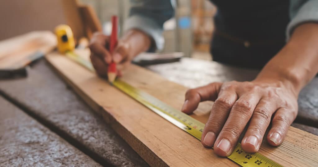 Carpenter Measuring a Piece of Wood