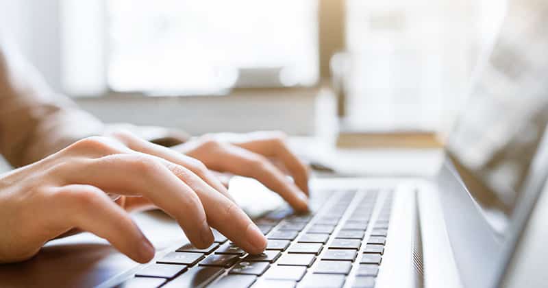 Closeup of Someone Typing on a Laptop