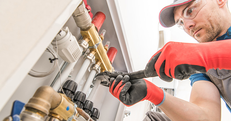 Plumber Tightening a Bolt on a Commercial Job Site