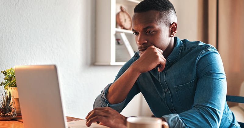 Man Looking at Online Reviews on a Laptop