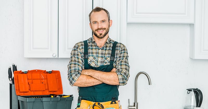 Successful Plumber Standing by a Sink