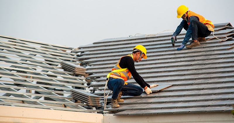 Two Roofers Installing Shingles