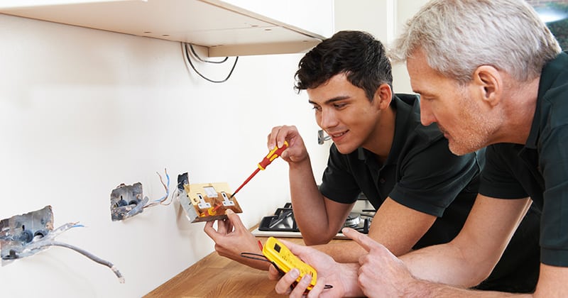 Experienced Electrician Working with an Apprentice