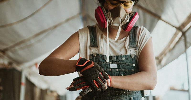 Female Construction Pro Putting on Gloves