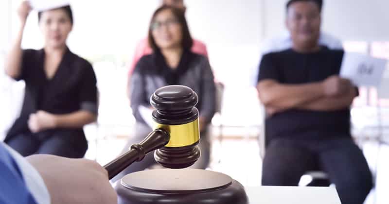 Gavel with Group Placing Bids in the Background