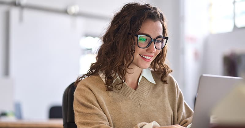 Woman Researching Bids on Laptop