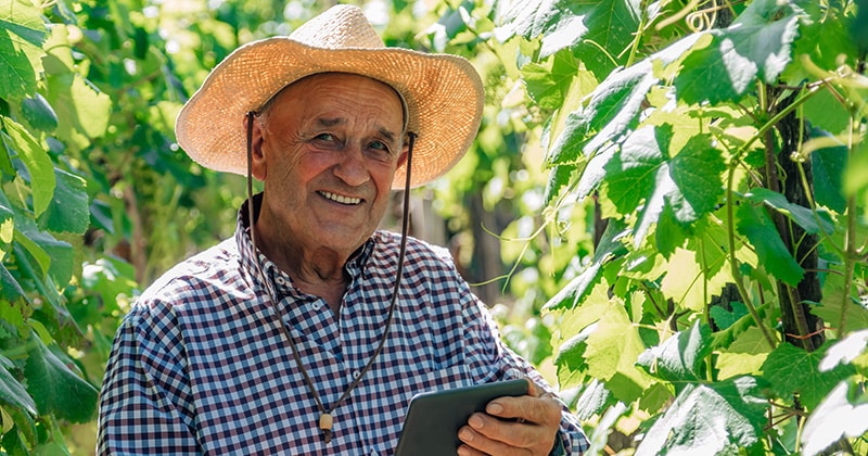 Happy Farmer on His Farm on a Tablet 