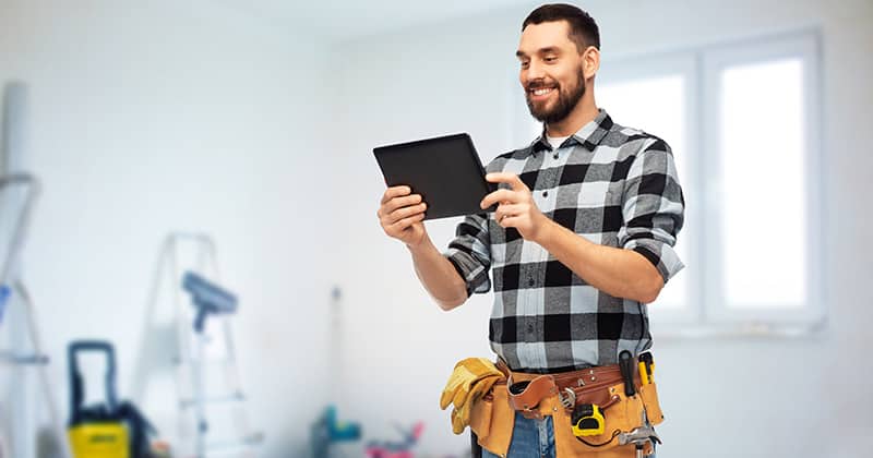 General contractor smiling at tablet on site