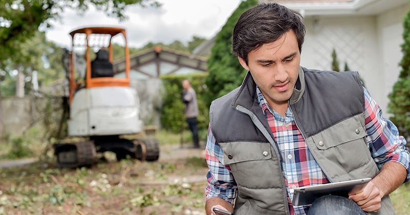 Male landscaper on tablet looking at leads on the job