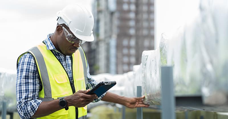 Male HVAC worker looking at tablet