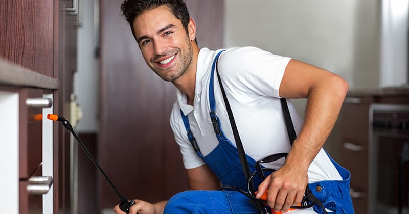 Pest control worker smiling at the camera at work