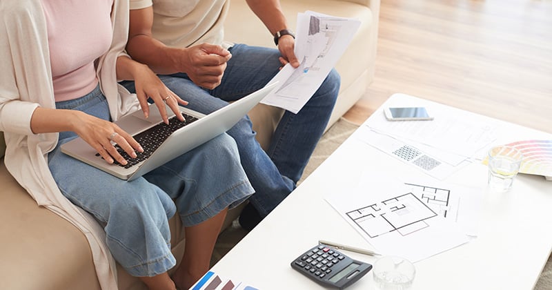 High angle of couple looking at remodeling plans