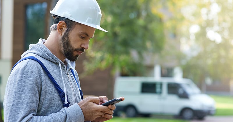 Male builder on smartphone