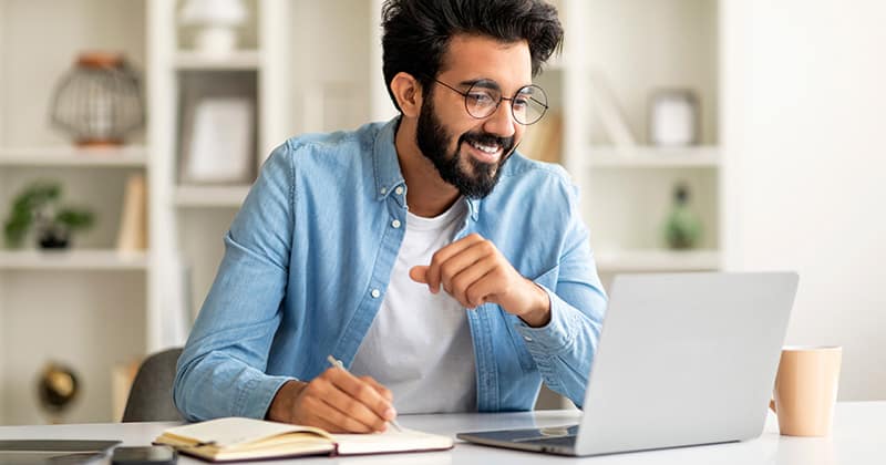 Smiling man doing research on laptop
