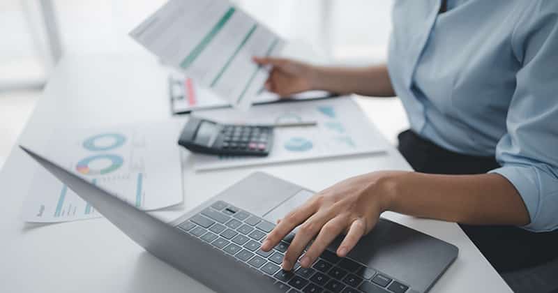 Woman looking at business documents and calculating