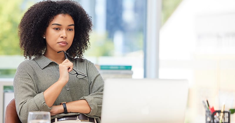 Woman looking at computer and contemplating