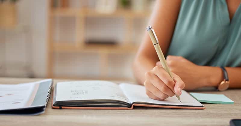 Woman writing in notebook and planning