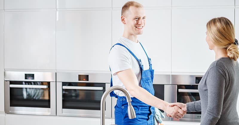 Plumber-shaking-hands-with-female-customer