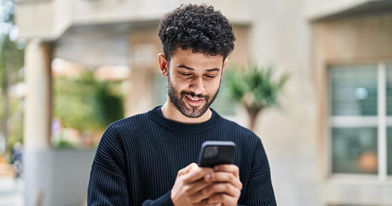 Man smiling and looking at phone