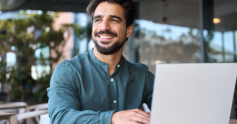 Man smiling and typing on computer