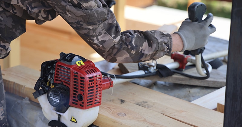 Foreman checks gasoline weed eater after winter storage