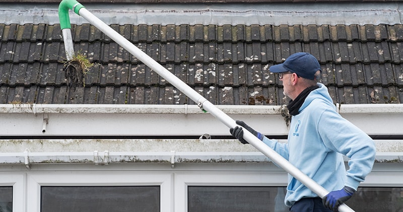 Gutter cleaner using tool to clean gutters