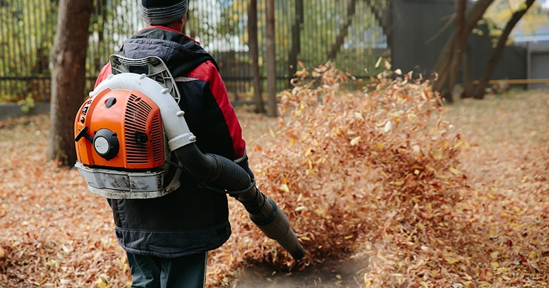 Man in coat uses a commercial leaf blower