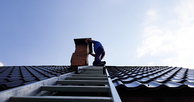 Ladder up to brick chimney