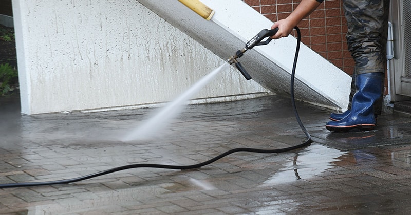 Using a pressure washer to clean a worksite