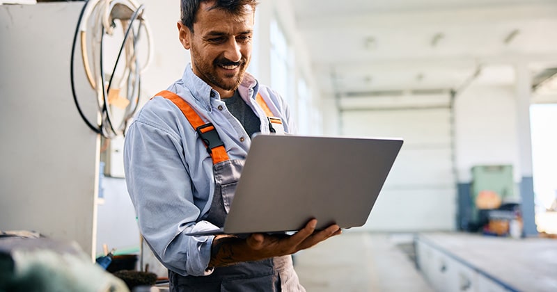 Contractor man holds laptop while optimizing local seo
