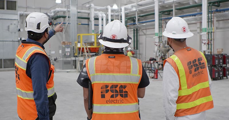 Three construction workers talking in warehouse