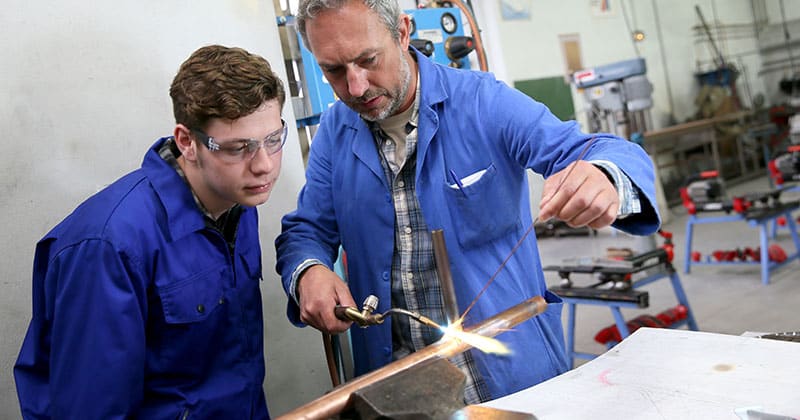 Plumbing student in workshop with teacher