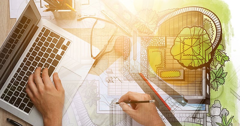 Landscape designer using laptop and drawing