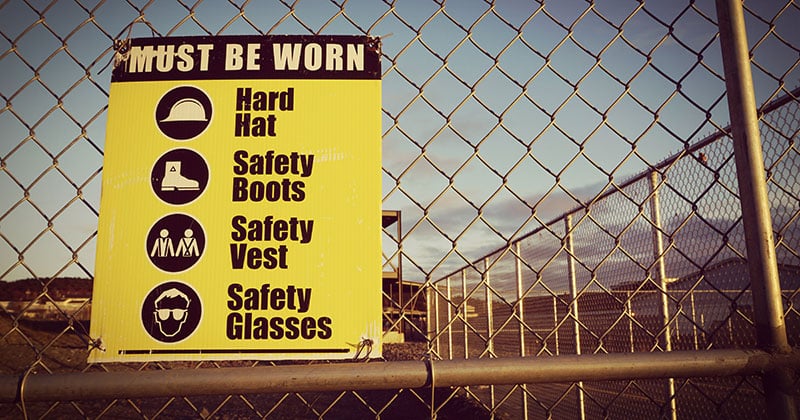 Construction PPE safety sign on fence