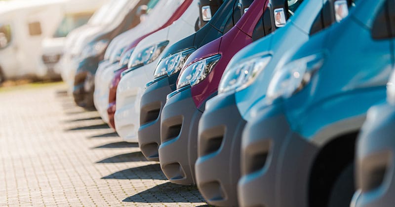 Variety of commercial fleet vehicles lined up in parking lot