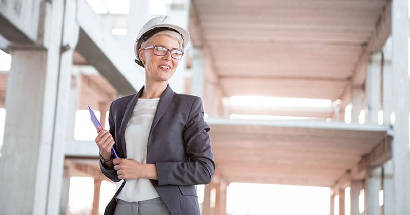 Female construction leader with clipboard on job site